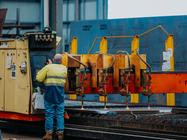 Man operating a machine for steel