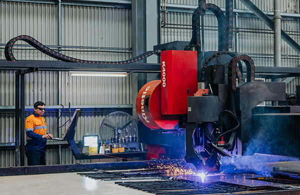 Man operating plasma cutting machine for steel